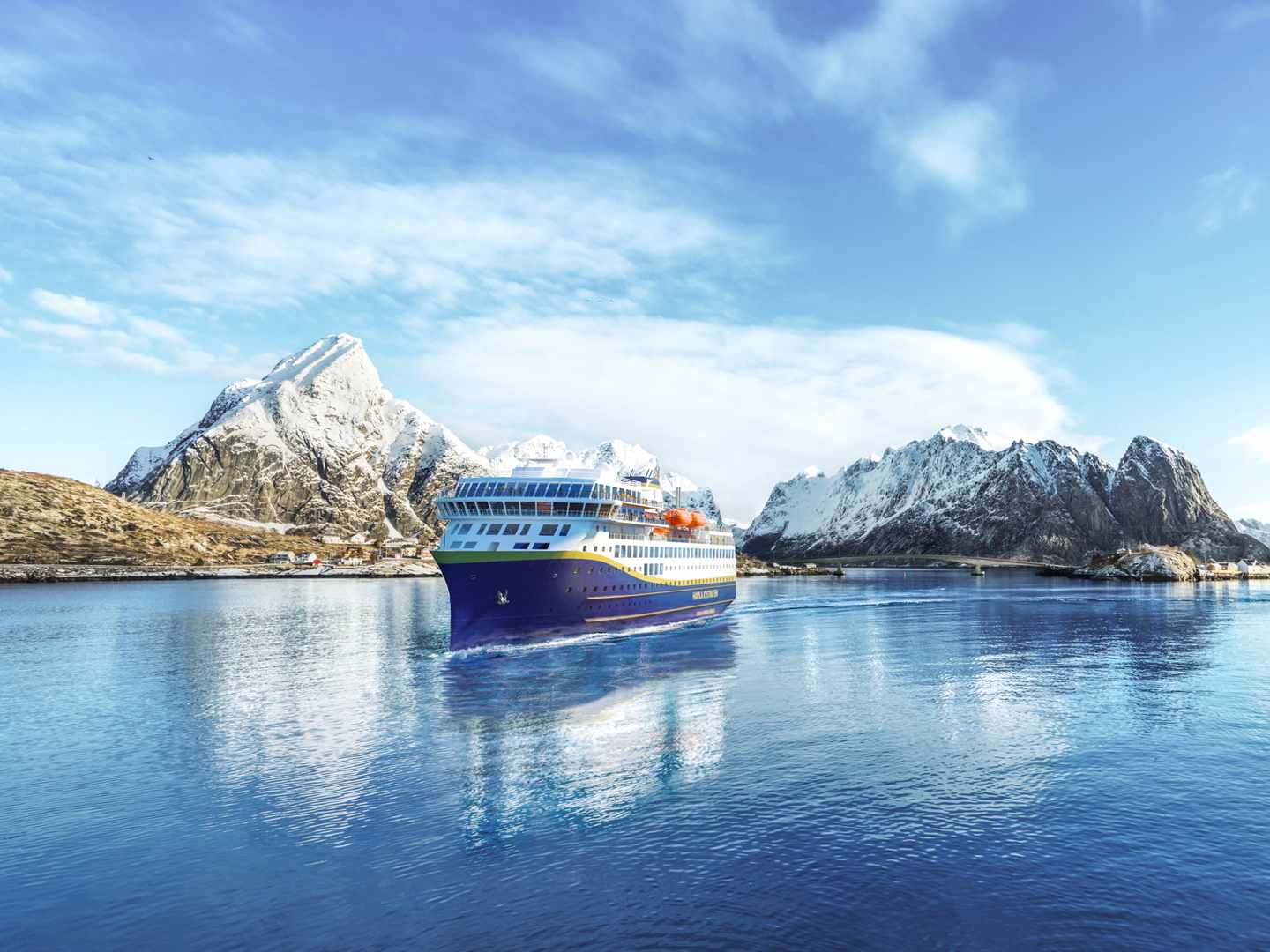 Kreuzfahrtschiff der Havila Voyages fährt während der Erlebnisreise durch einen norwegischen Fjord vorbei an schneebedeckten Bergen