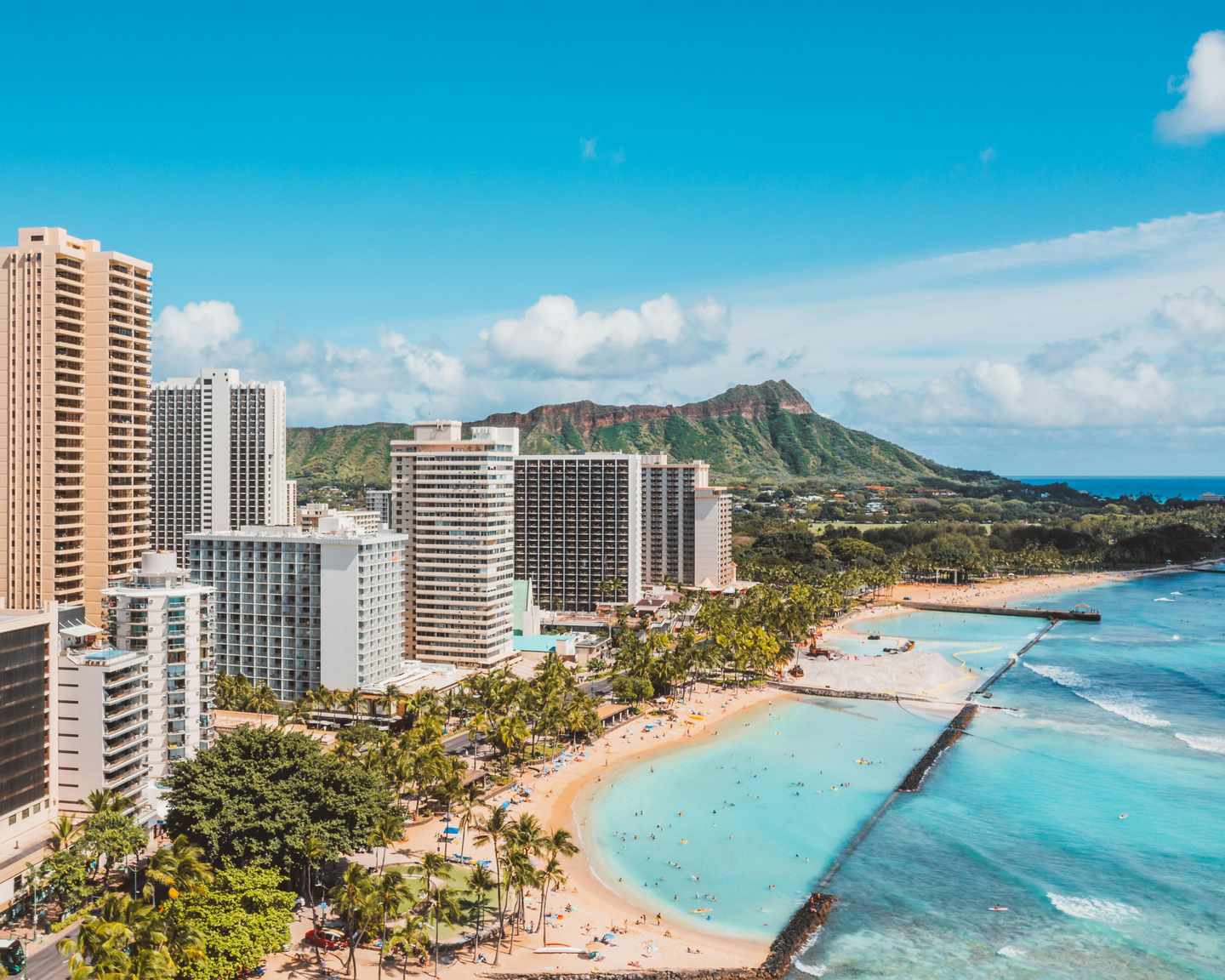 GettyImages-2236168733.jpg Aufnahme aus der Vogelperspektive des Waikiki-Strandes und der Skyline von Honolulu mit dem Diamond Head im Hintergrund an einem sonnigen Tag