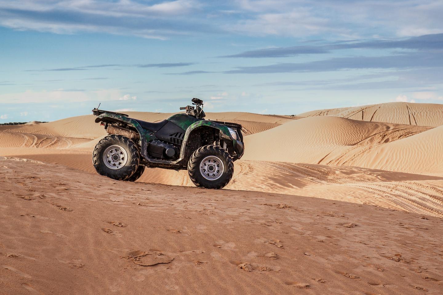 Quad zwischen Sanddünen in der Wüste Tunesiens