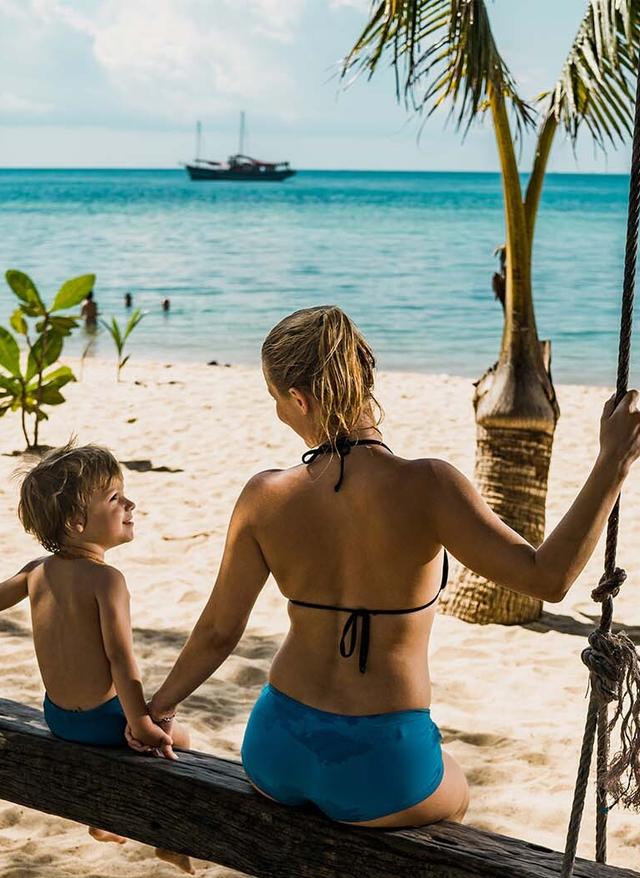 Familienurlaub Thailand thailand-familienurlaub-rueckansicht-des-mutter-und-sohn-hand-in-hand-beim-schwingen-am-strand-g-1069482872.jpg