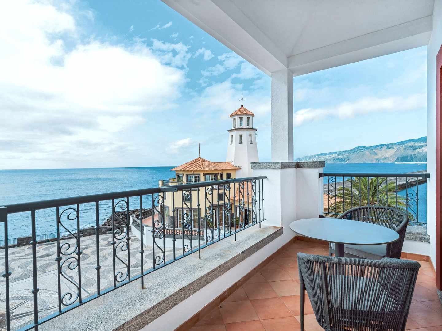 DER1588329.jpg Balkon mit Sitzgruppe und Blick auf das Meer sowie einen Leuchtturm am Hyatt Ziva Madeira in Caniçal