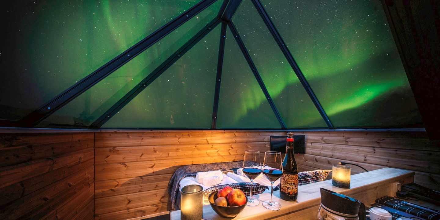 blt4cc525040faa1c29-polarlichter-hotels-Star_Arctic_Hotel-DER1309439.jpg Blick in ein Zimmer mit Glasdecke und Polarlichtern