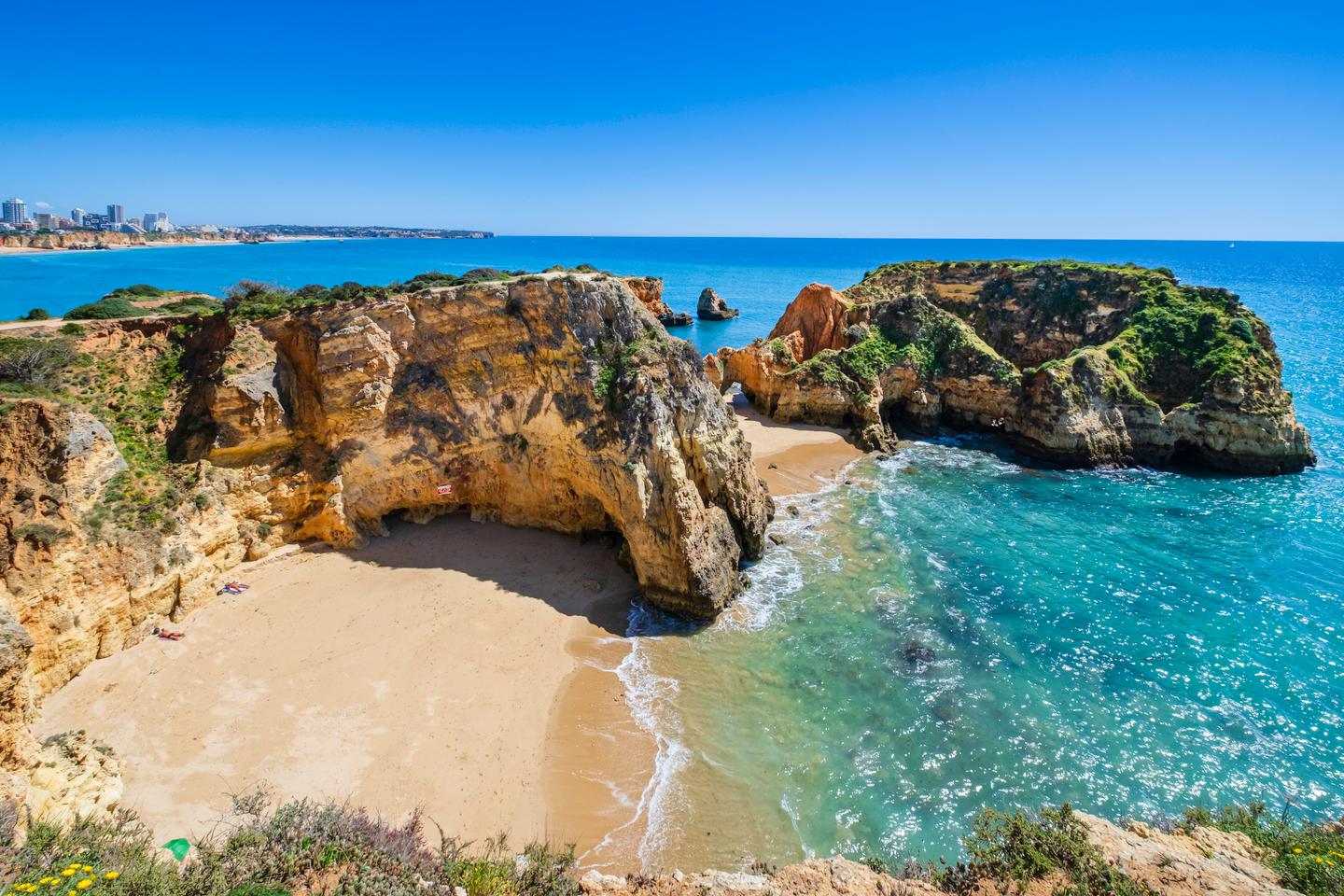 Geschützte Sandbucht Praia João de Arens mit markanten Felsklippen und türkisfarbenem Atlantik an der Algarve