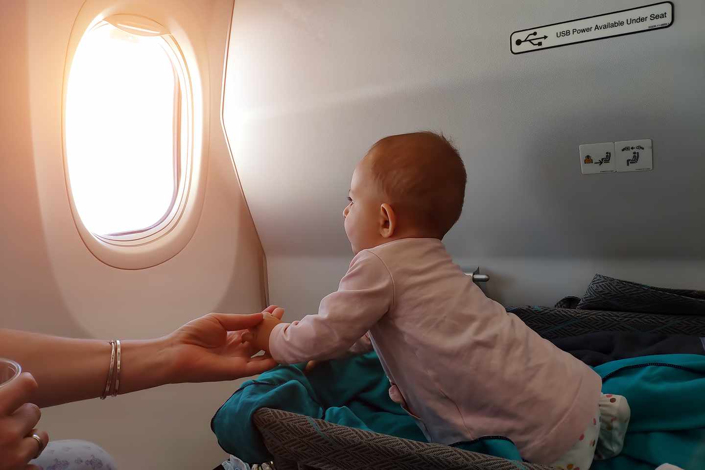 blt00c96cd25d320d62-kinder-fliegen-baby-flugzeug-g-1160026904.jpg Baby im Flugzeug schaut aus dem Fenster