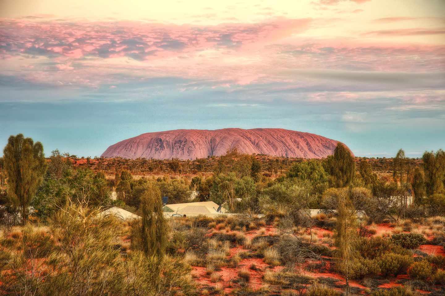 Outback-Piste mit Blick auf Uluru im roten Zentrum Australiens 