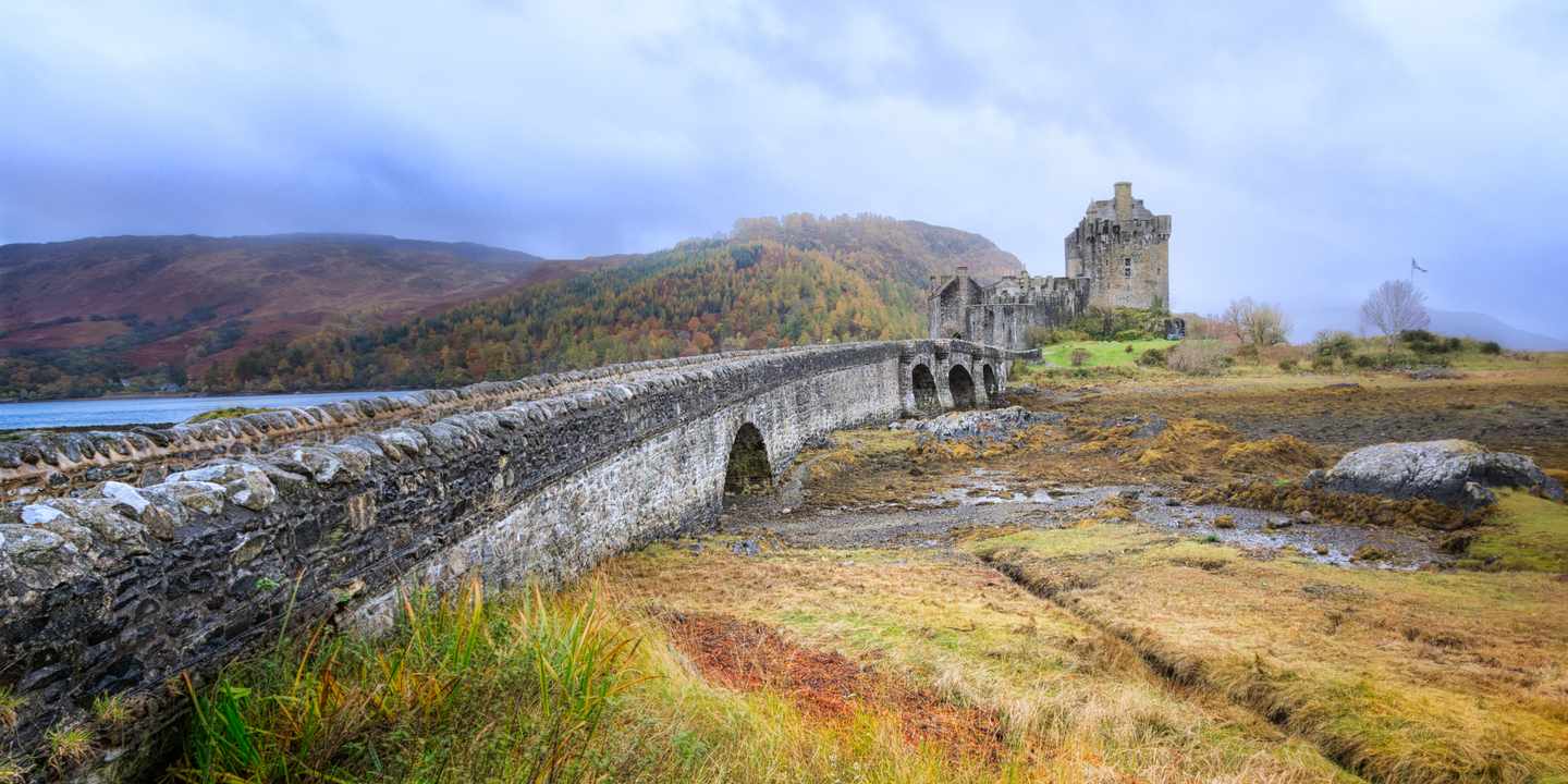 Eine steinerne Brücke verbindet Eilean Donan Castle auf einer kleinen Felseninsel mit dem Ufer