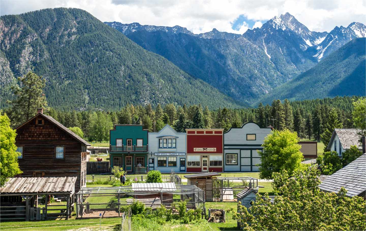 Historische Holzhäuser von Fort Steele vor bewaldeten Bergen der Kootenay Rockies in British Columbia