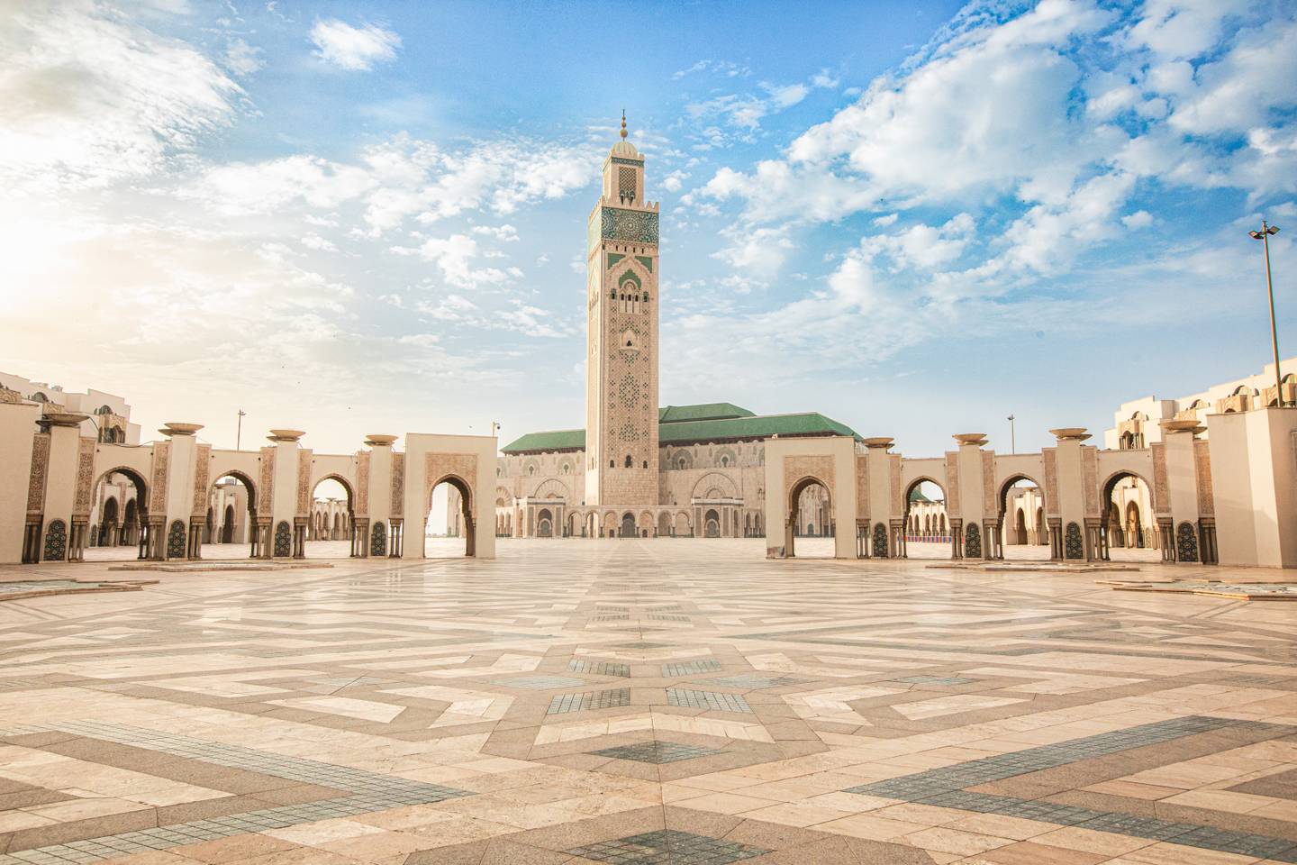 ONMT CASABLANCA_21.jpg Cassablanca - Platz mit quadratisch gepflasterten Mustern auf dem Boden und im Hintergrund Turm mit grünen Verzierungen