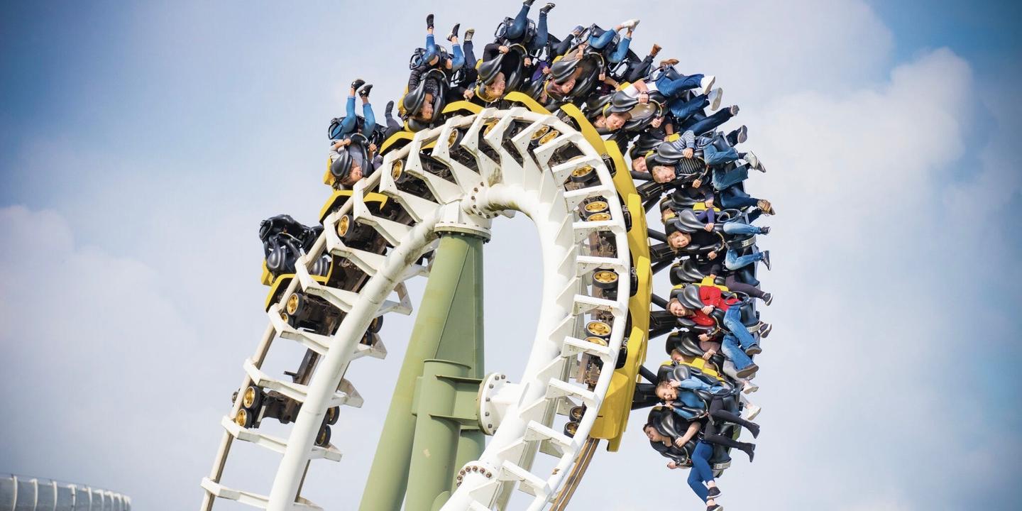 Passagiere auf einer freischwingenden Achterbahn mit Looping