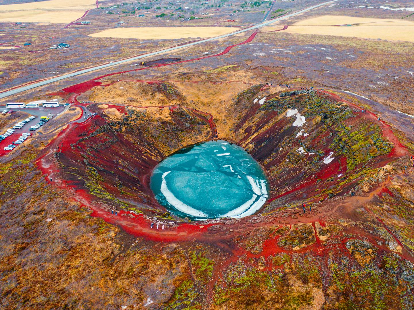 Blauer Krater in roter Vulkanlandschaft