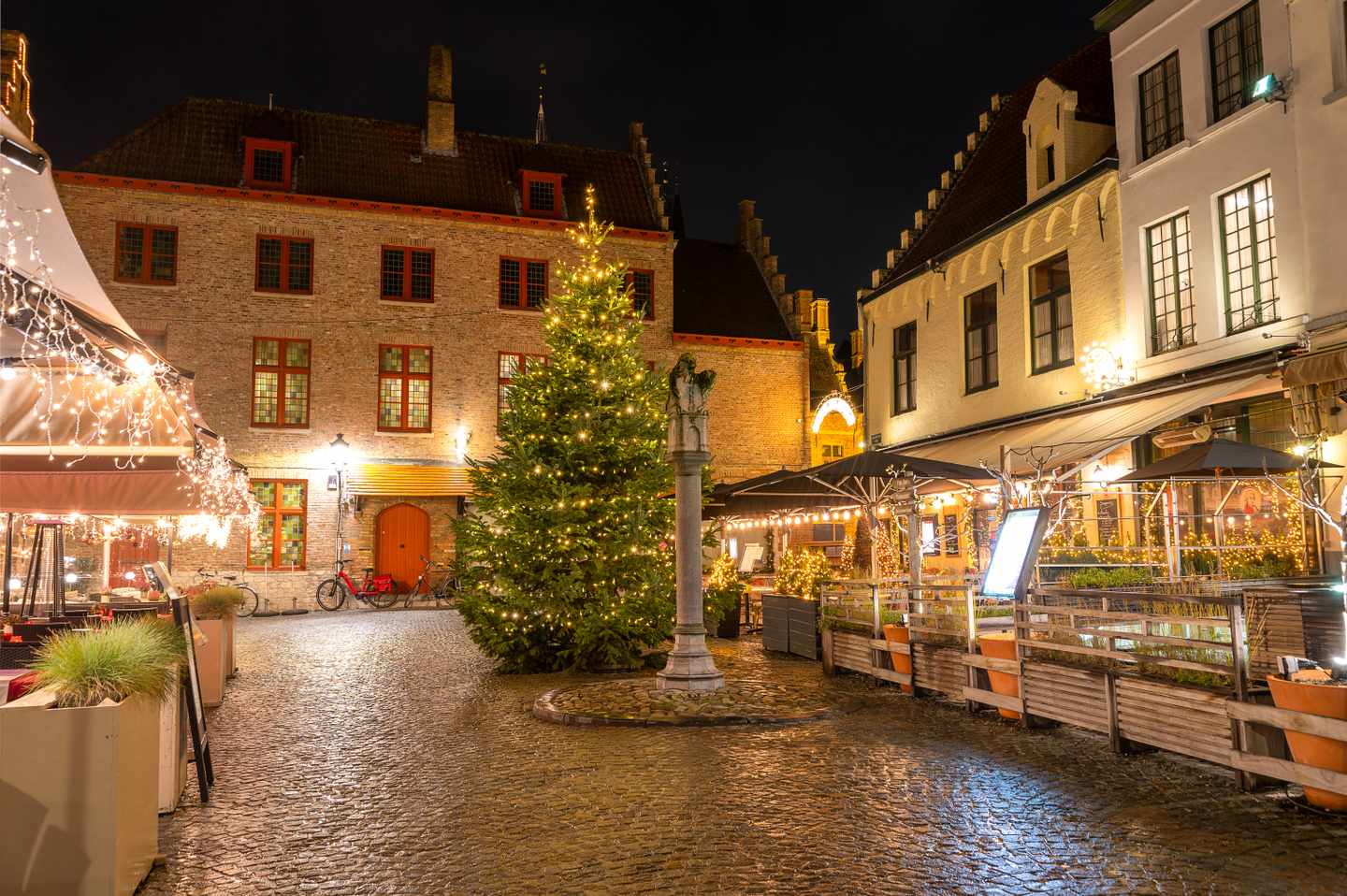Beleuchteter Weihnachtsbaum zwischen historischen Backsteinhäusern in der Altstadt von Brügge