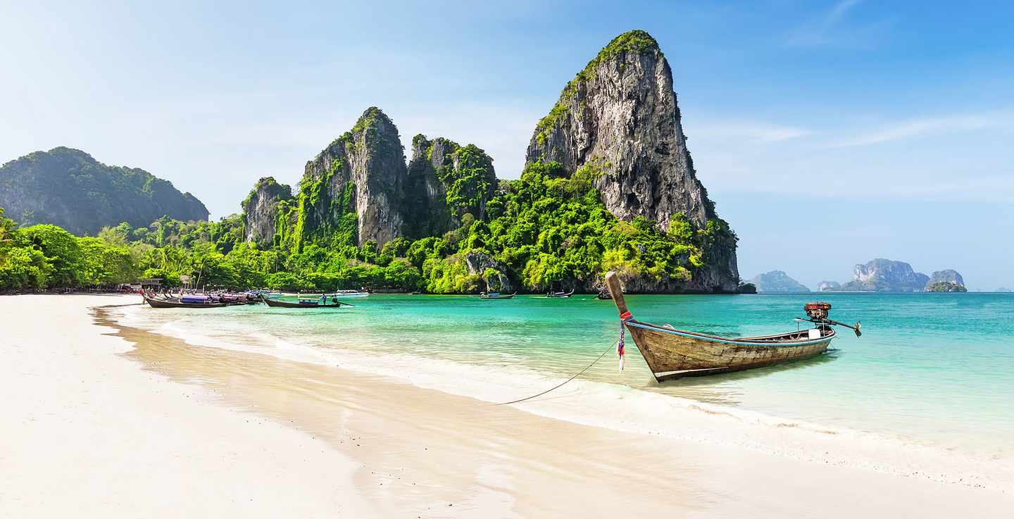thailand-strandurlaub-traditionelles-boot-ankert-vor-grossen-felsen-im-tuerkisen-wasser-g-1206899165.jpg