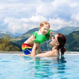 familienurlaub-mutter-und-kind-in-einem-pool-vor-bergkulisse-g-969118102.jpg