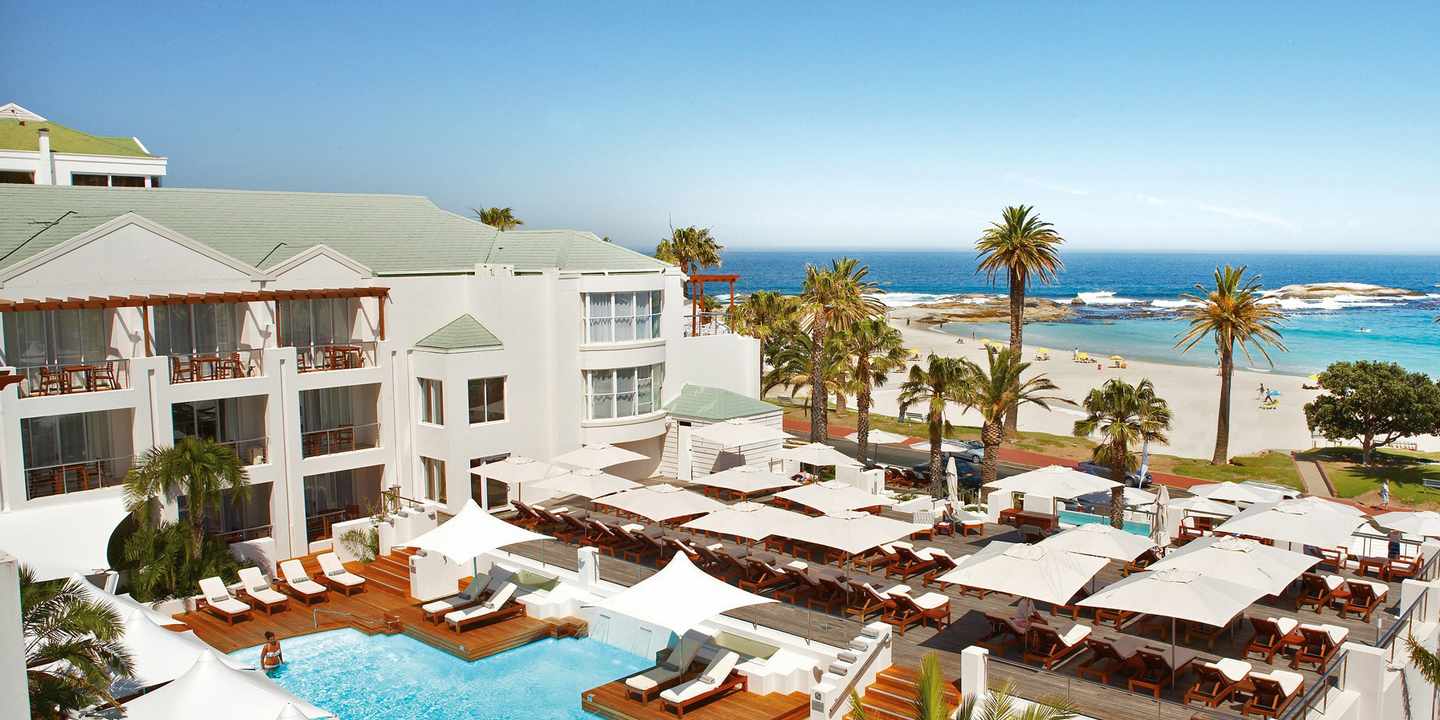 The Bay Hotel in Kapstadt mit Poolterrasse, Sonnenliegen und direktem Blick auf den Strand von Camps Bay und den Atlantik