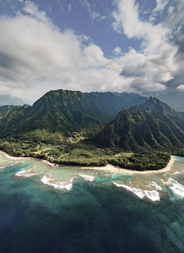 Kauai Urlaub Kauai Urlaub mit DERTOUR. Luftaufnahme der Na-Pali-Küste auf Kauai mit Strand und bergigem Urwald dahinter