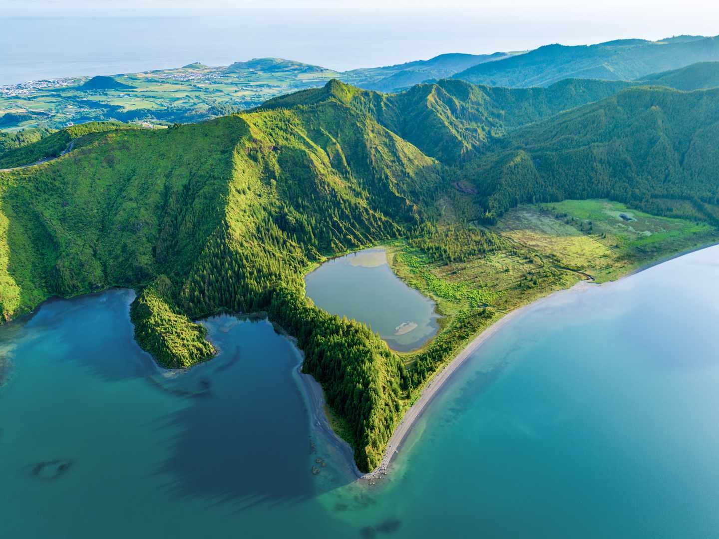 Luftaufnahme der Lagoa do Fogo auf São Miguel mit Kratersee, bewaldeten Hängen und Atlantikküste auf den Azoren