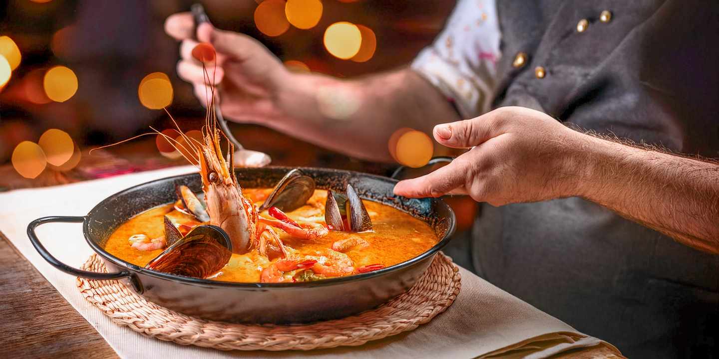 spanien-menorca-caldereta-de-langosta-513195_AdobeStock_1051051933_Faceless-man-eat-Caldereta-de-Langosta-in-restaurant-with-bokeh-background-Spanish-Food.jpg