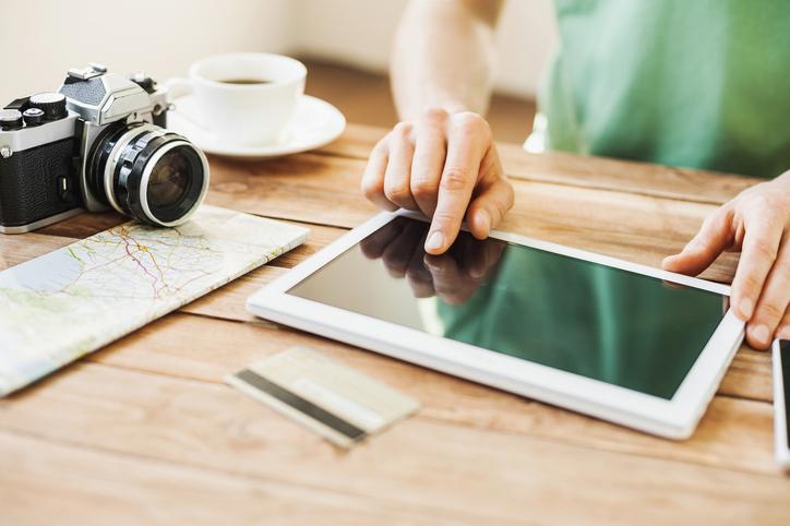 Mann am Tablet bei der Reiseplanung