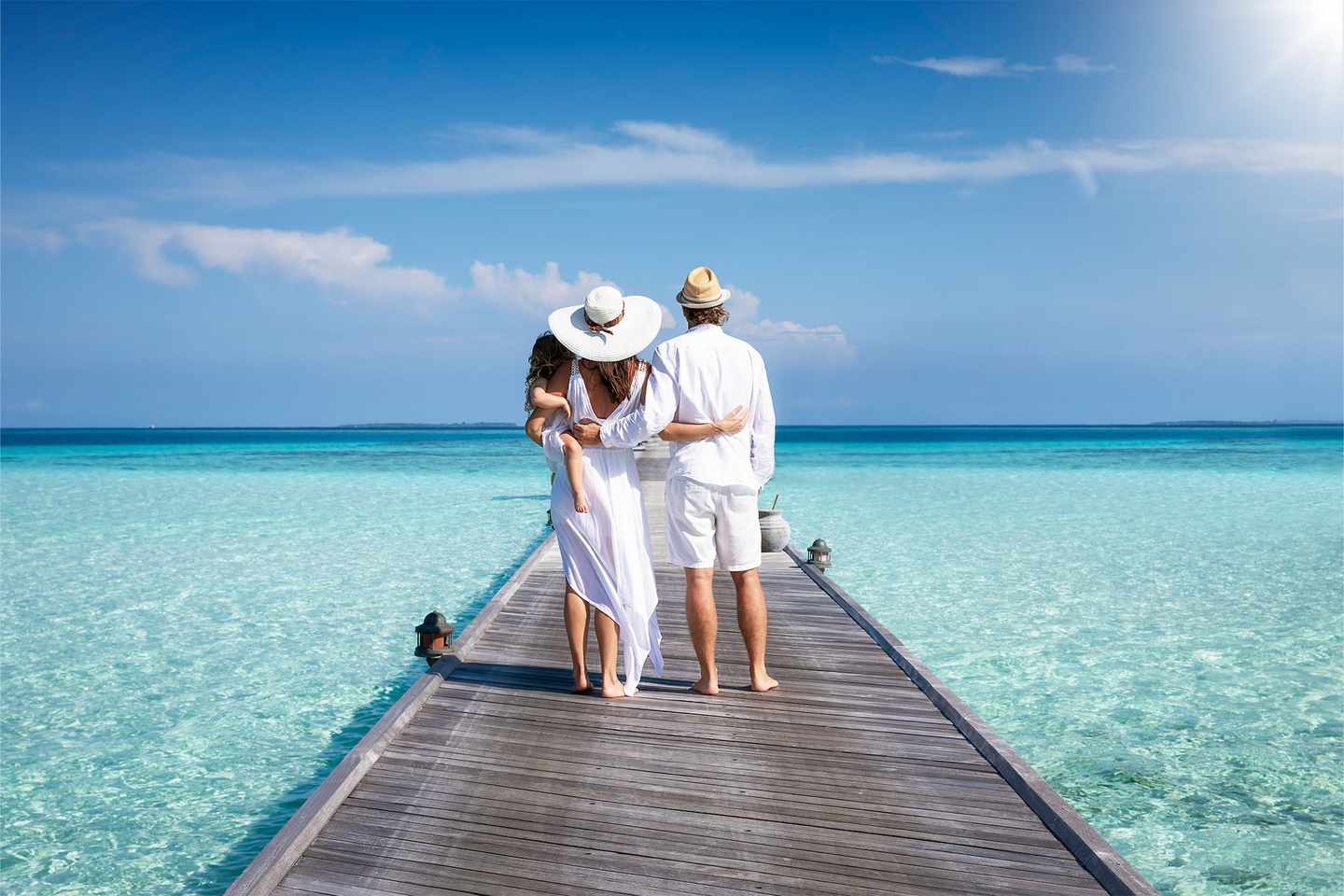 luxus-familienurlaub-eine-familie-in-weisser-sommerkleidung-.steht-auf-einem-pier-auf-den-malediven-g-1352015743.jpg