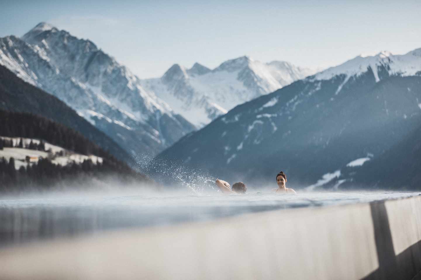 Paar im Pool: Tiroler Hotels mit Pool zwischen den Bergen