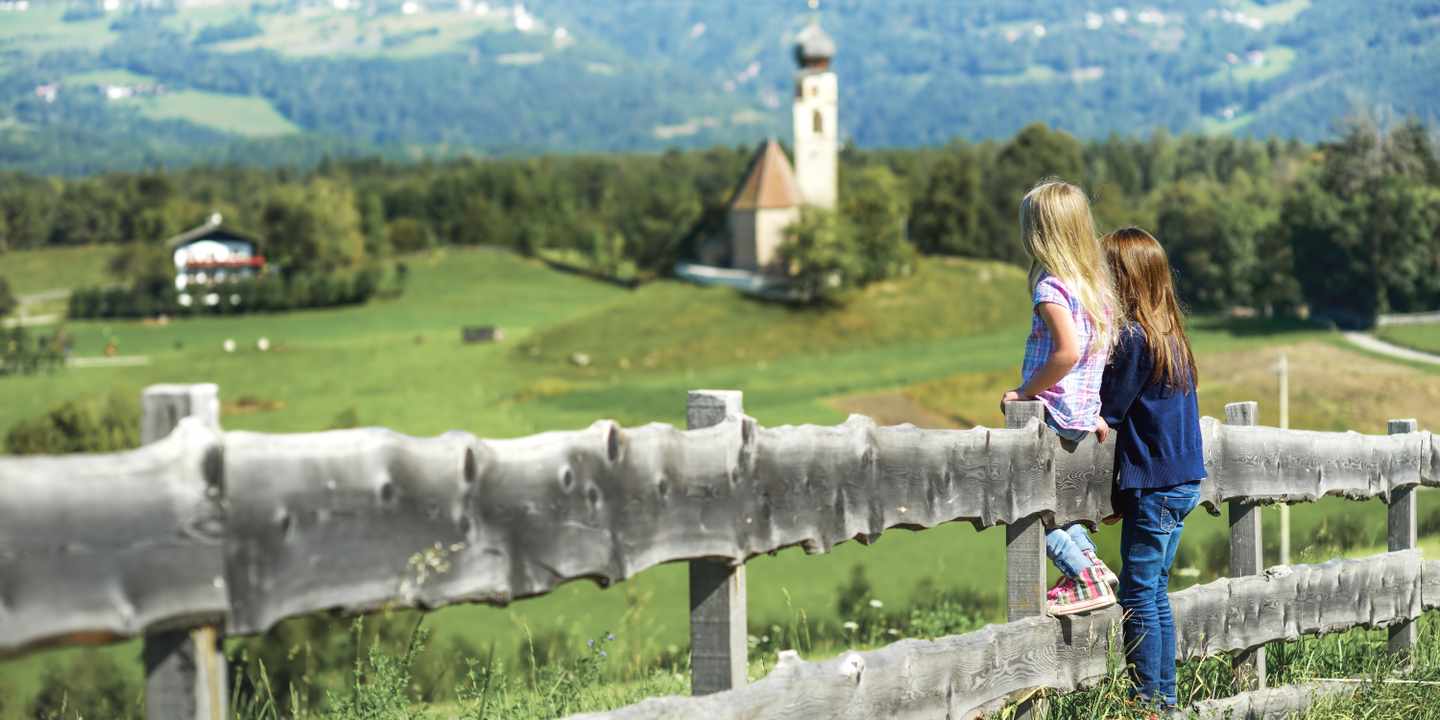 italien-suedtirol-zwei-kinder-an-einem-zaun-blicken-auf-die-dolomiten-g-1445526426.jpg