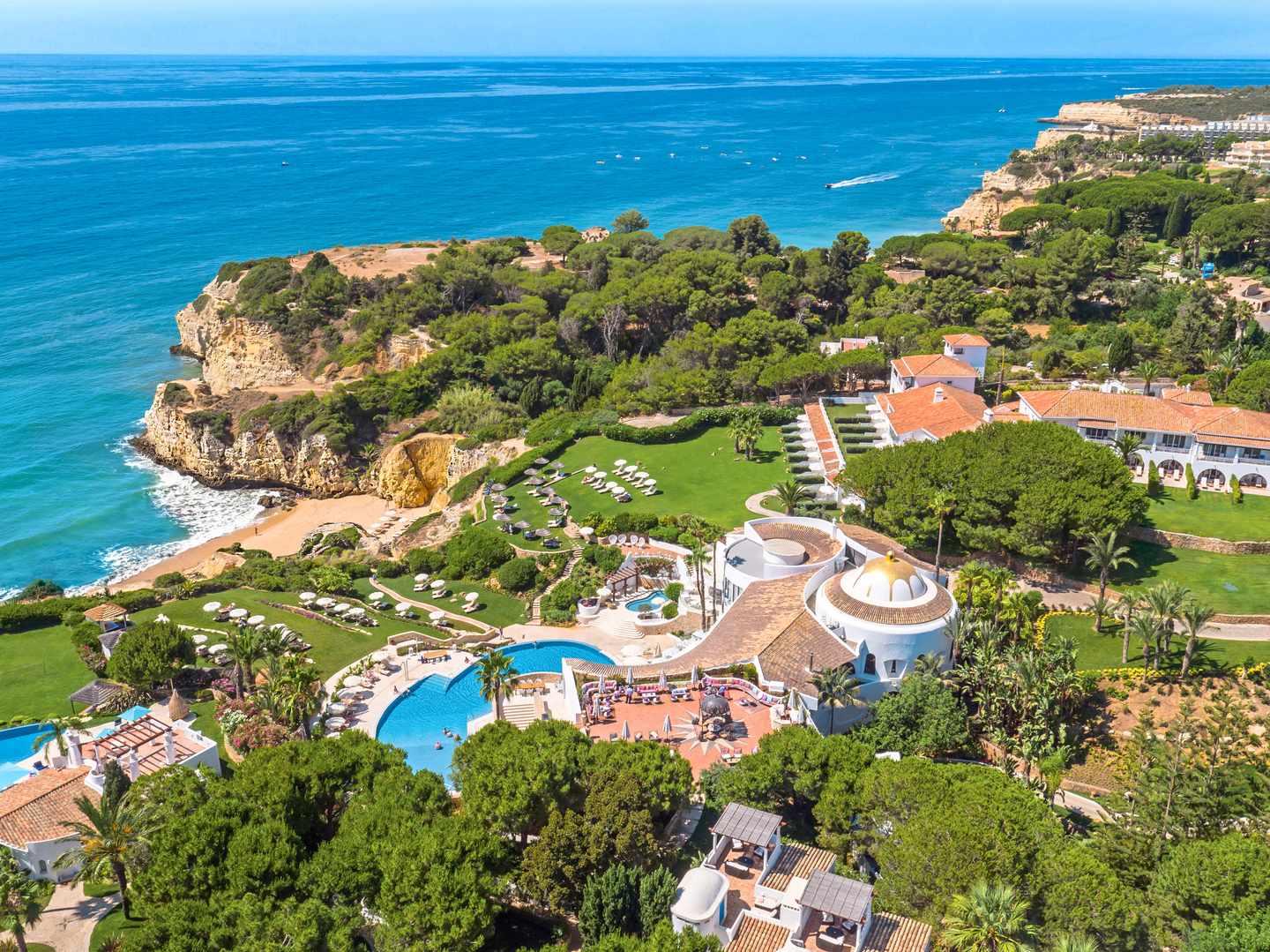 Luftaufnahme des Vila Vita Parc in Porches an der Algarve mit Poollandschaft, Gärten und direkter Lage über den Felsen am Atlantik