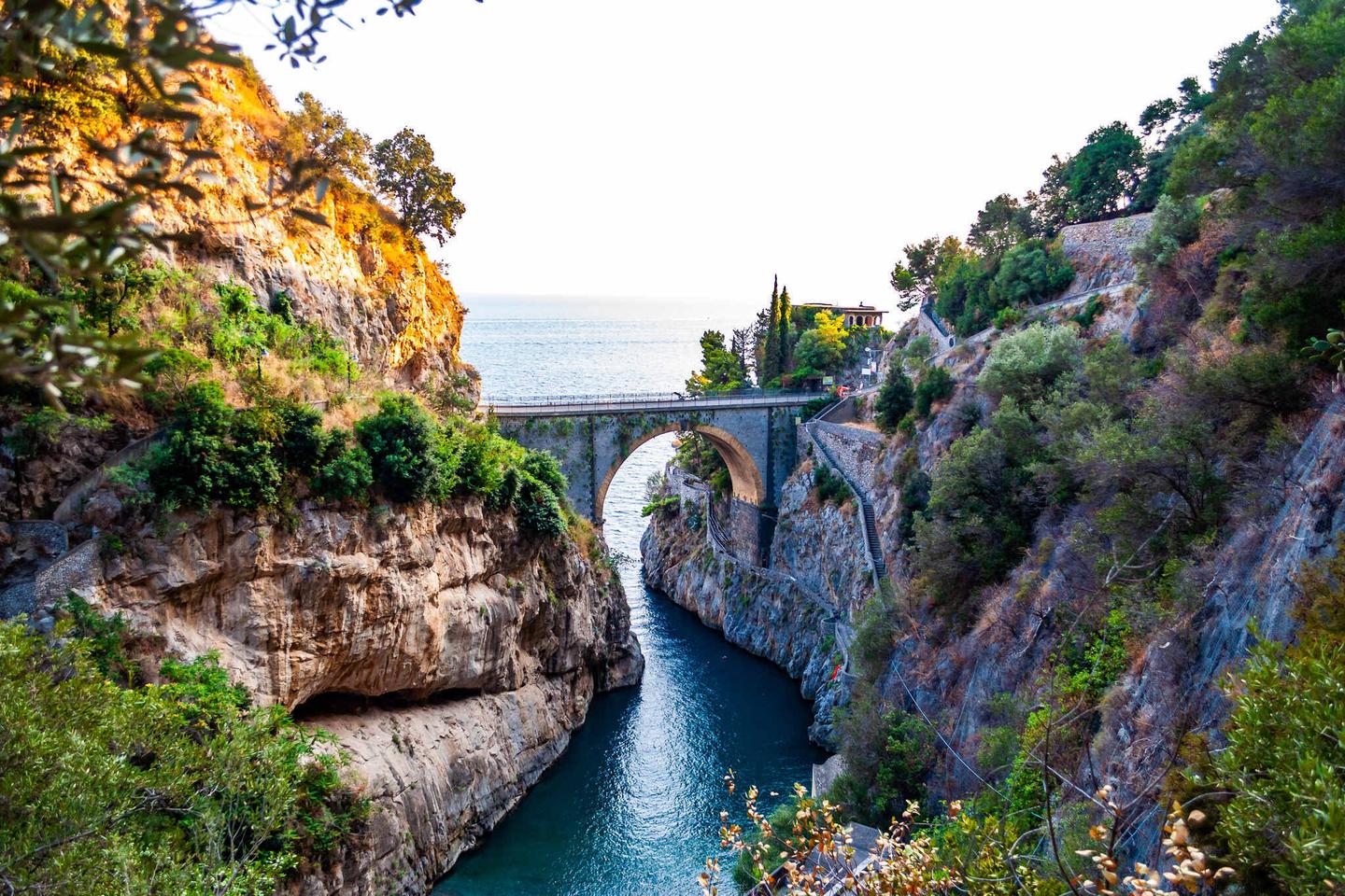 italien-hero-roadtrip-blick-auf-fiordo-di-furore-bogenbrueke-zwischen-hohe-gelsigen-klippen-über-der-tyrrhenischen-meeresbucht-in-kampanien-region-gebaut-g-1191496278.jpg