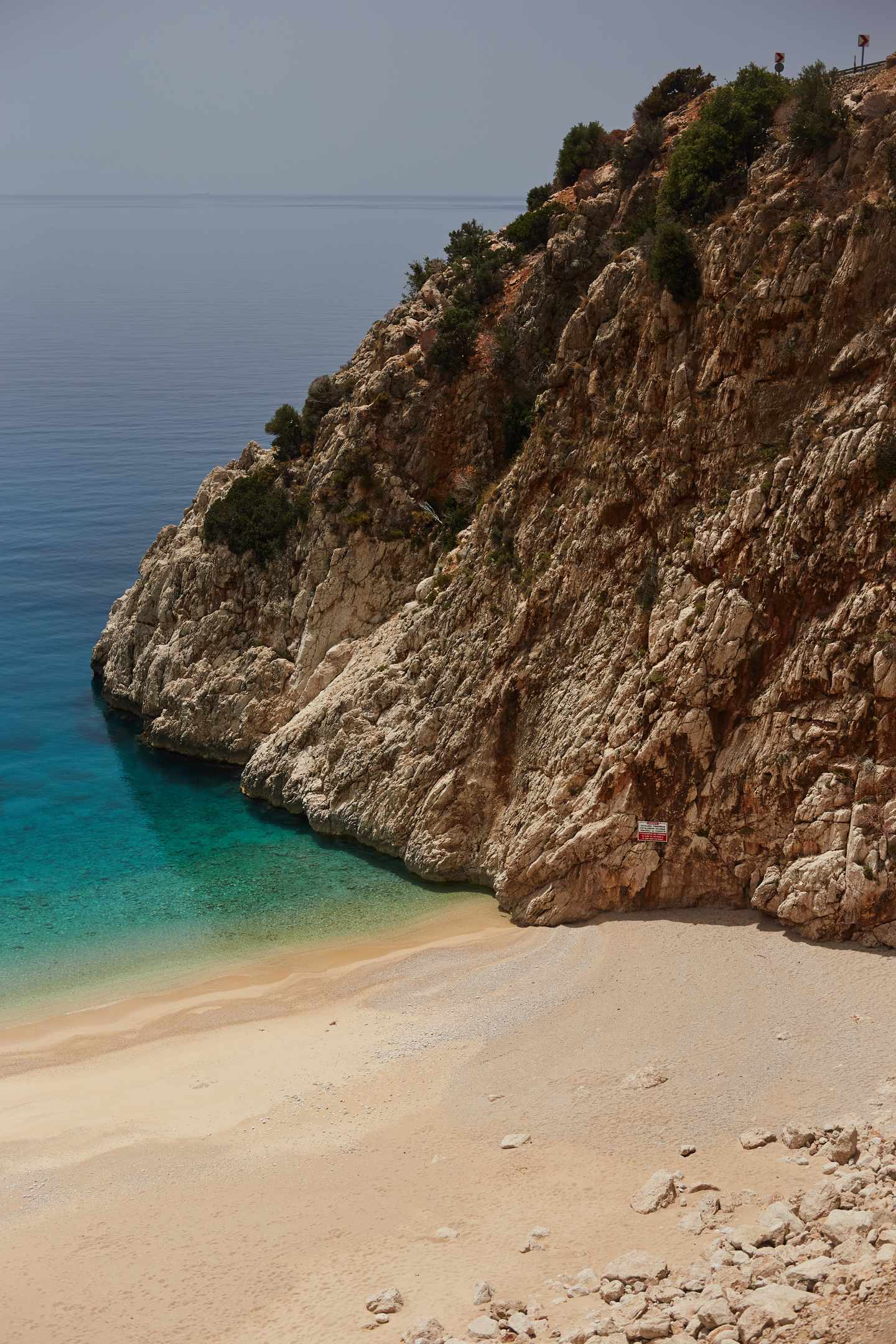 GettyImages-1240136840.jpg Landschaftsaufnahme eines Mittelmeerstrandes mit goldenem Sand  blauem Meer und einer Felsformation