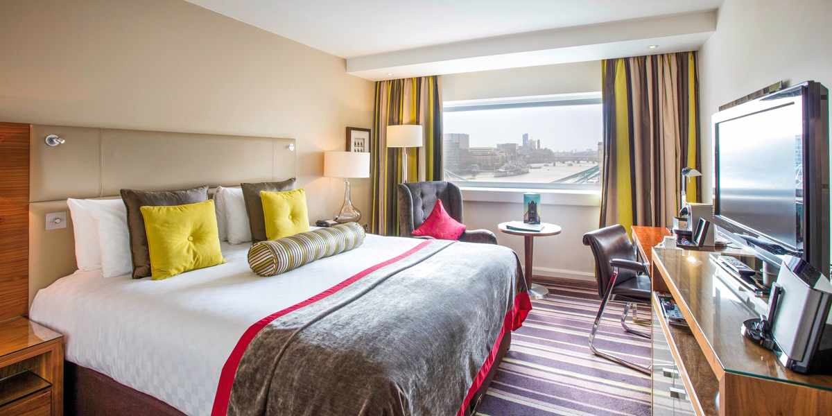 bltb33c7d9c9a9ca6ec-grossbritannien-england-london-tower-hotel-LON05001BC_W25-D18G2425_4.jpg Blick auf ein Hotelzimmer, durch das Fenster sieht man die Themse im Hintergrund