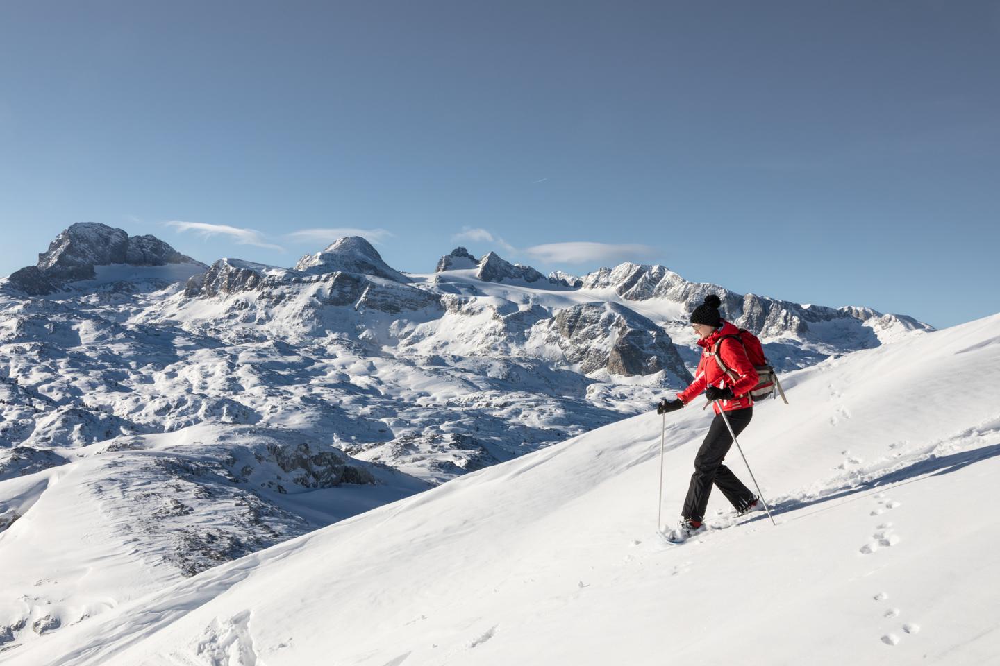 Frau wandern mit Schneeschuhen in den Bergen