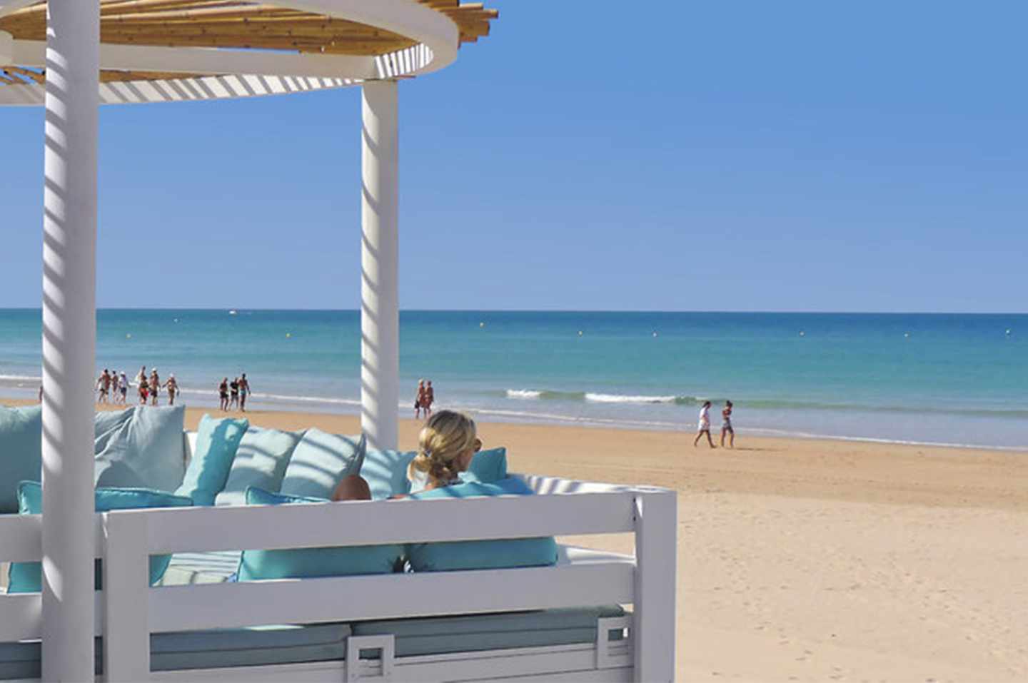 Frau sitzt in einer Strandbar am andalusischen Strand