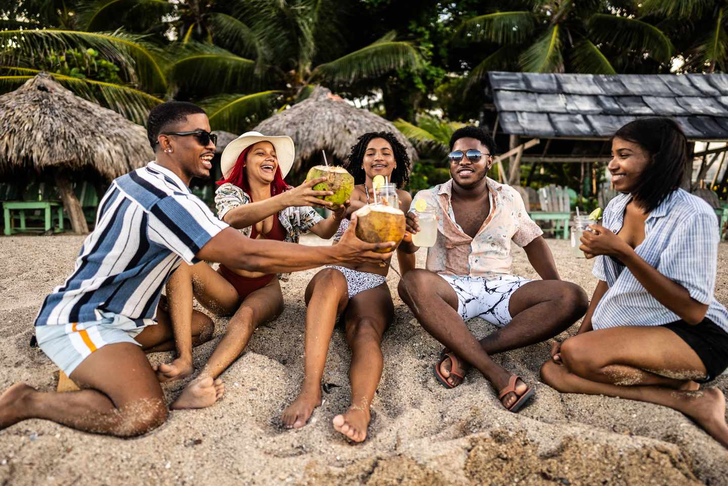 junge-freunde-stossen-am-strand-an-g-1791219047.jpg