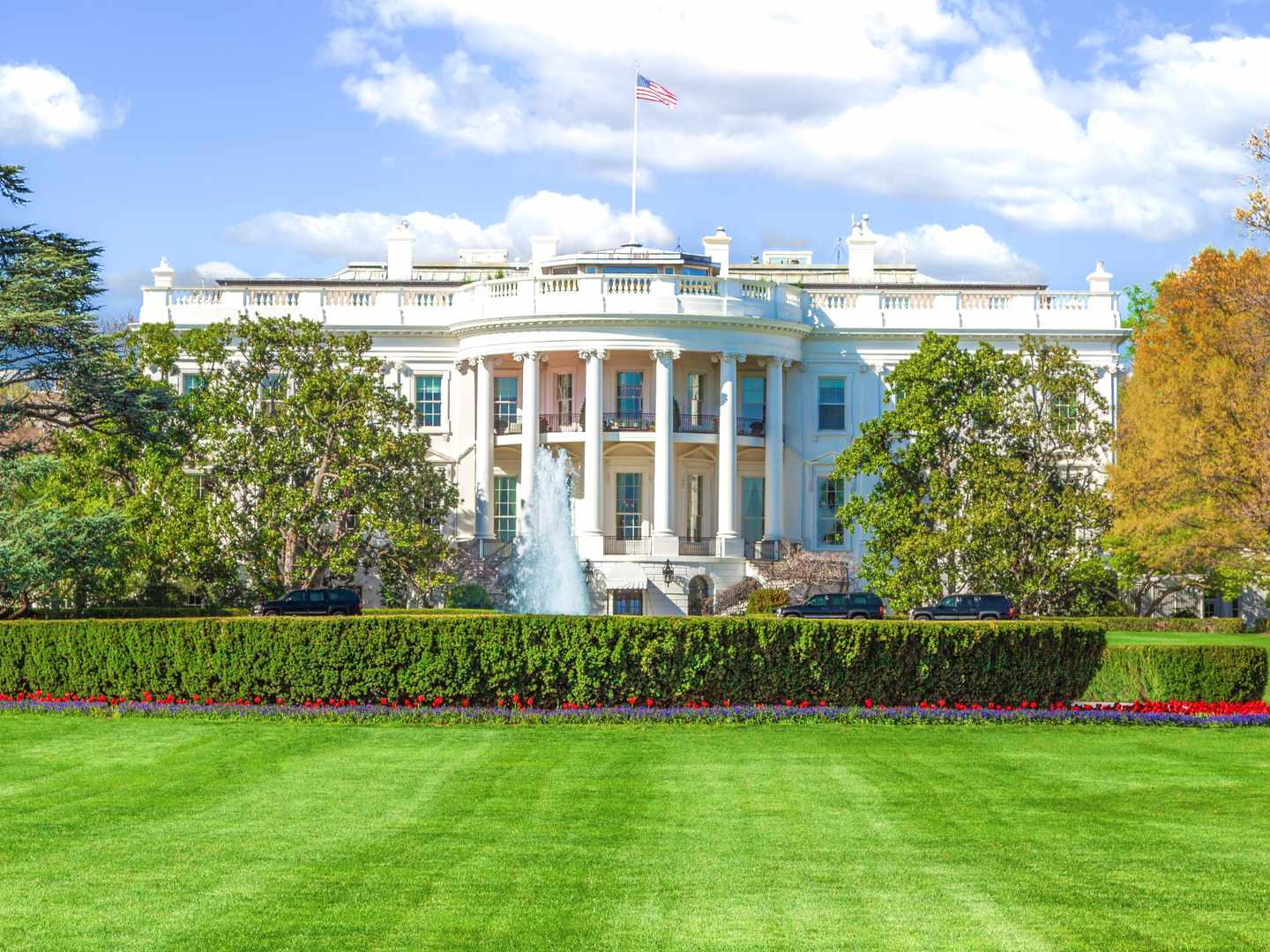 Das Weiße Haus in Washington D.C. mit Brunnen und Garten unter blauem Himmel