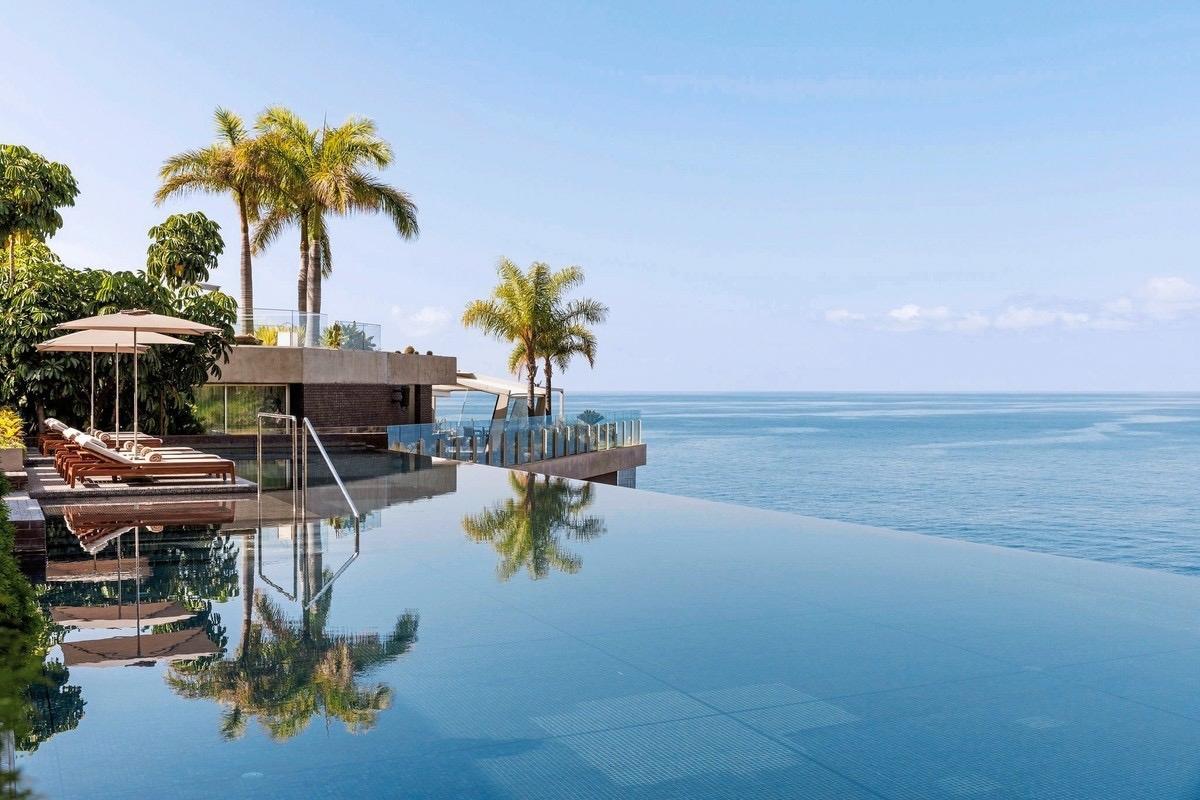 blt93728eb565b5d580-Portugal-Madeira-Calheta-h-Saccharum_Resort_1.jpg Infinity-Pool des Saccharum Resort auf Madeira mit Palmen, Liegen und weitem Blick über den Atlantik