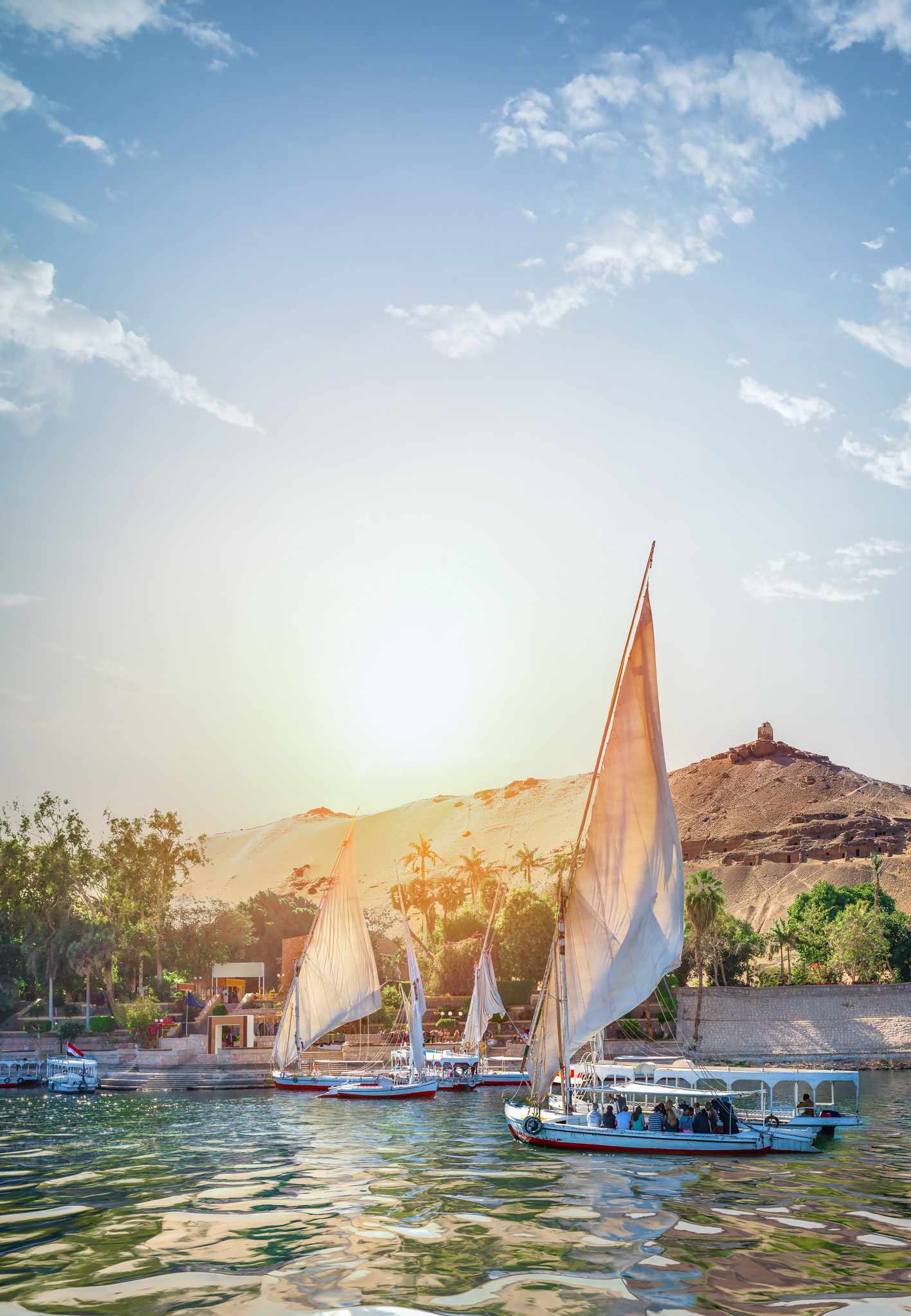 GettyImages-1149276915.jpg Traditionelle Feluken auf dem Nil bei Assuan während des Sonnenuntergangs in Oberägypten