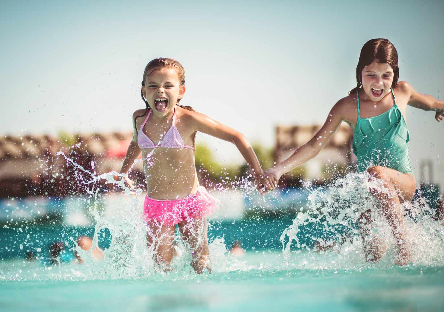 familienurlaub-zwei-maedchen-laufen-durch-einen-pool-g-1226560982.jpg