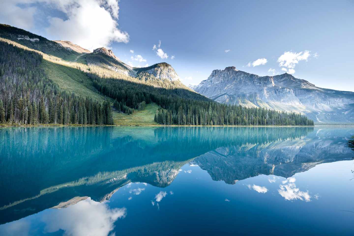 Emerald Lake mit türkisfarbenem Wasser und Spiegelung bewaldeter Berge im Yoho-Nationalpark in British Columbia
